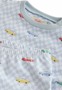 Lichtblauw shirt met korte mouwen en een geruit patroon, versierd met kleurrijke auto-illustraties in rood, geel, groen en blauw. Zacht katoen.