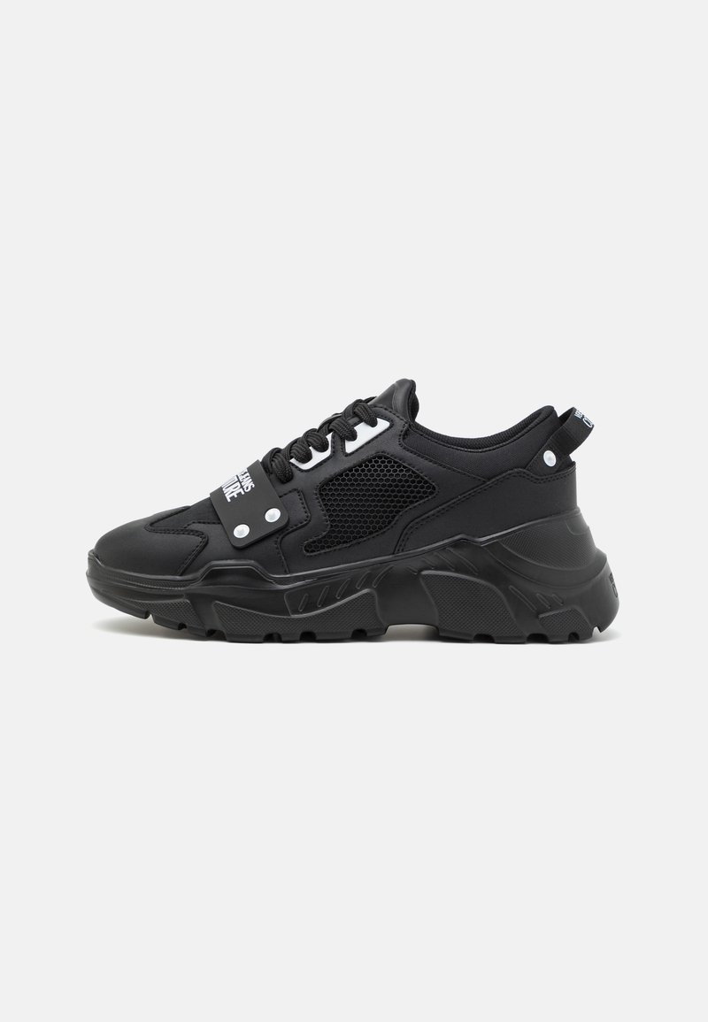 Schwarze Sneaker mit chunky Sohle, Obermaterial aus Mesh und synthetischen Materialien, runder Zehenbereich, gepolsterter Schaft und weißen Akzenten an der Zunge und an den Seiten.