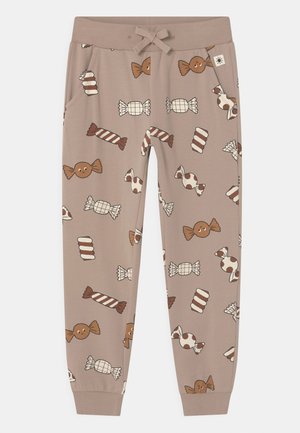 Pantalones jogger infantiles beige con cintura elástica, cordón, bolsillos laterales y estampado de caramelos en marrón, blanco y crema por todas partes.