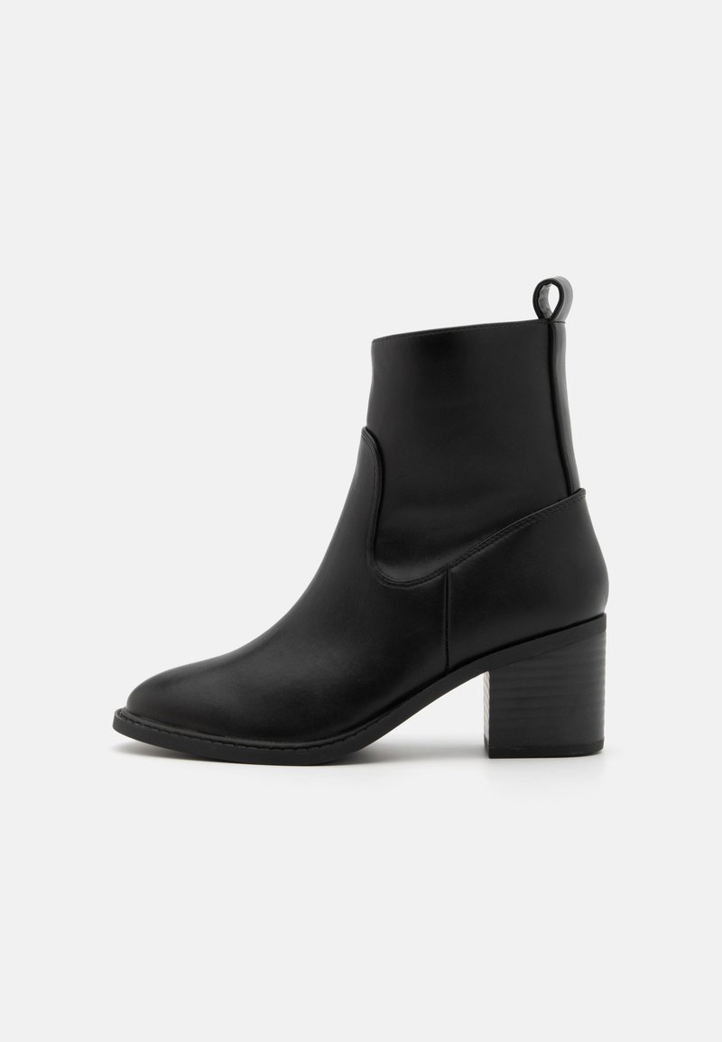 Bottines en cuir noir avec un bout arrondi, un talon bloc de hauteur intermédiaire et une languette à l'arrière pour un enfilage facile.