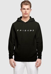 Černá mikina s kapucí a šňůrkami, na přední straně s nápisem "FRIENDS" bílou barvou a barevnými tečkami mezi písmeny. Přední klokanková kapsa.