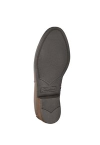 Schoenzool met een gestructureerde zwarte rubberen bovenkant, met een lichtbruine rand en een afgeronde hak, gemarkeerd met "Skechers."