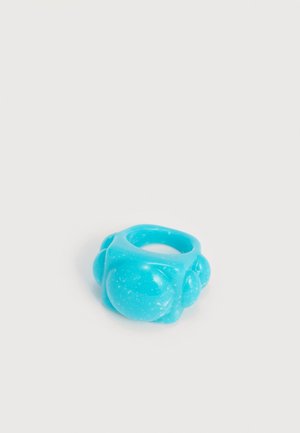 Bague épaisse en résine bleu vif avec des protubérances arrondies semblables à des bulles sur un fond blanc uni.