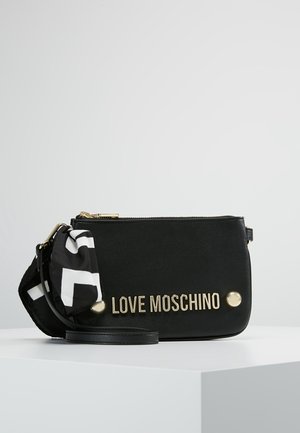 Pochette-bracelet rectangulaire noire Love Moschino avec lettrage doré, clous dorés, fermeture éclair et accessoire en tissu à motifs noir et blanc.