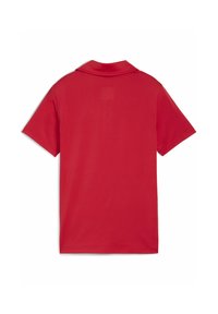 T-shirt polo rouge uni vu de dos, avec un col court et des manches courtes, présenté sur un fond blanc.