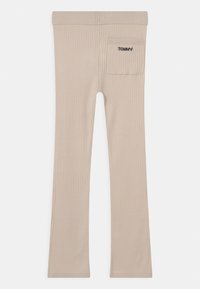 Beige Rippstrick-Hosen mit geradem Schnitt und einer quadratischen Gesäßtasche, die auf der rechten Seite mit "TOMMY" bestickt ist.