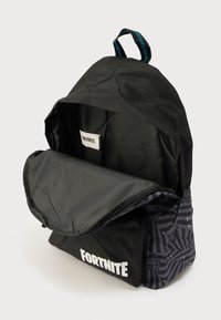 Μαύρο σακίδιο με αντίθετη σκουρόχρωμη πλευρά με σχέδιο, μεγάλο κύριο διαμέρισμα, λαβή στο πάνω μέρος και λογότυπο "FORTNITE" τυπωμένο στο μπροστινό μέρος.