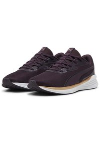 Zapatillas deportivas moradas con parte superior de malla, punta redondeada, suela plana y logotipo de marca destacado. Presentan acentos en blanco y dorado que contrastan.