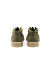 Scarpe alte in suede verde oliva con suola in gomma marrone e dettagli cuciti. Presentano una texture morbida e un design casual.