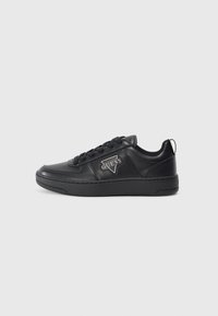 Zapatilla de cuero negro con puntera redonda, parte delantera con cordones y detalle de logotipo en el lateral. Presenta una suela texturizada y altura hasta el tobillo.