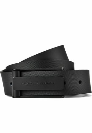 Cinturón de cuero negro con hebilla rectangular negra mate grabada con "Porsche Design", enrollado sobre un fondo blanco.