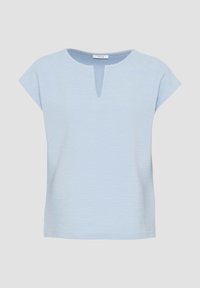 Světle modrý krátký rukáv žebrovaný top s malým výstřihem do V a kulatou štítkovou nálepkou "OPUS" na jednobarevném pozadí.