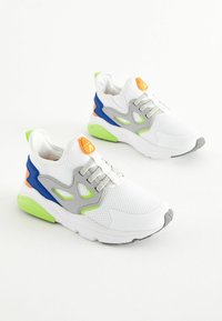 Hvide sports sneakers med mesh-overdele, grå accenter og flerfarvede detaljer i blå, orange og neon grøn. Rundet tå med gummisål.
