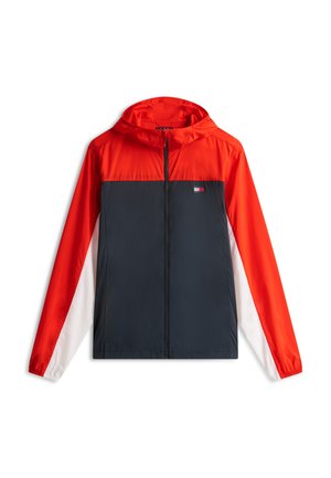 Παιδικό αδιάβροχο μπουφάν με κουκούλα, με κόκκινο ανώτερο τμήμα, σκούρο μπλε μεσαίο και λευκά κάτω μανίκια, με μικρό λογότυπο στο στήθος.