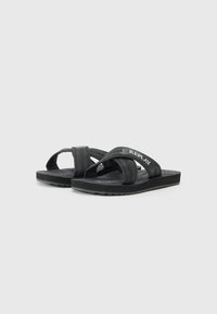 Black flip-flops featuring two fabric straps with textured patterns, a cushioned sole, and a rubber bottom with a tread design.