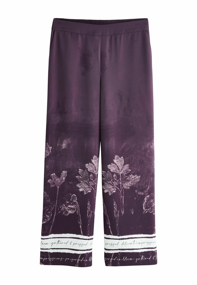 Lilla bukser med vide ben, botanisk mønster og hvid skriftkant langs sømmen, med elastisk linning.