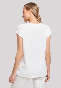White cotton t-shirt with rolled short sleeves, rounded neckline, and a relaxed fit. Smooth texture with a plain design. Back view visible.