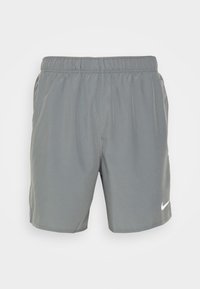 Harmaat urheilushortsit, jotka on valmistettu kevyestä kankaasta. Niissä on joustava vyötärö ja valkoinen Nike-logo vasemmassa alakulmassa.