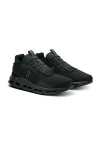 Een paar zwarte sportieve hardloopschoenen met gecushioneerde zolen, vetersluiting en merknamen op de zijkanten en de tongen.