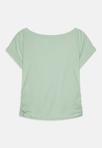 Haut à manches courtes vert menthe avec une coupe décontractée, encolure en cœur et ourlets roulés. Tissu en coton doux, texture lisse, détail froncé à l'arrière.