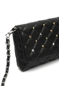 Borsa nera in ecopelle trapuntata con accenti di stelle e cuori in oro e argento, dotata di una tracolla a catena e design con pattina pieghevole.