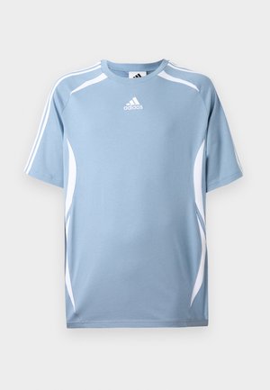 Gaiši zils sporta T-krekls ar īsām piedurknēm, baltām akcentiem sānos un mazu Adidas logo uz krūts. Mīksta auduma.