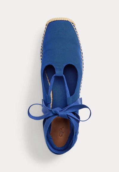 Plava platnena espadrila sa četvrtastim vrhom, izrezanim bočnim stranama, vezicama za omot oko gležnja i pletenim potplatom od juta, prikazuje smeđu kožnu unutarnju tabanicu s utisnutim logotipom.