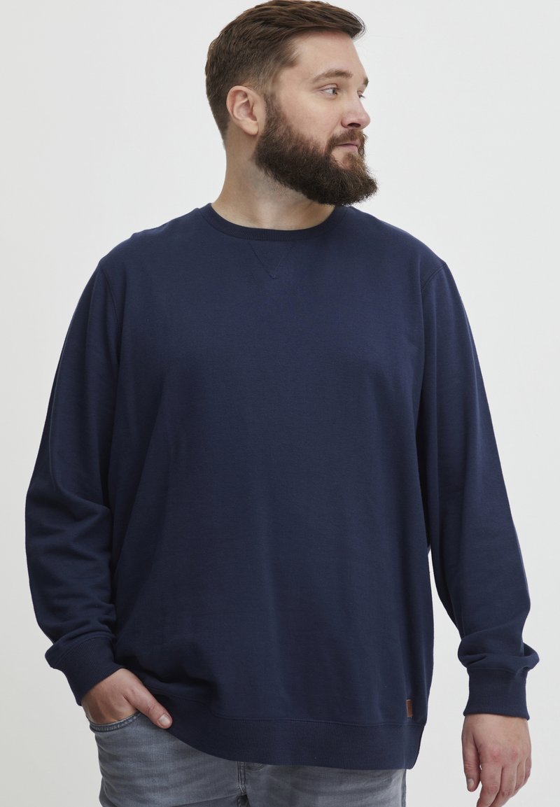 Felpa blu navy realizzata in tessuto morbido con collo giro, maniche lunghe e polsini a coste, caratterizzata da un piccolo badge con logo vicino all'orlo.