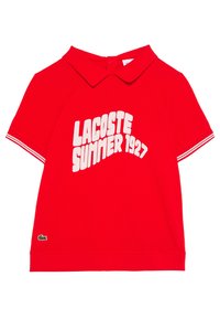 Czerwona koszulka polo z prążkowanym kołnierzykiem, krótkimi rękawami z białymi paskami oraz wyraźnym białym napisem "LACOSTE SUMMER 1927" na przodzie.