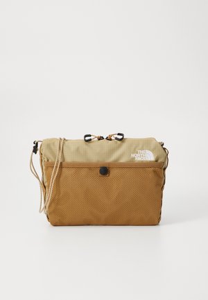 Light brown bag with a textured mesh base and smooth top panel. Features adjustable cords and a logo. Compact, rectangular shape.