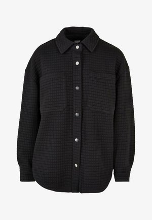 Musthave musterniga kohvikreemiga must särk-jakk, klassikalise kraega, kahe esipocketiga ja hõbedaste nööpidega.