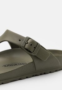Olivengrøn Birkenstock sandal med en tekstureret læderrem, justerbar spænde og let gummisål med en kontureret fodseng.