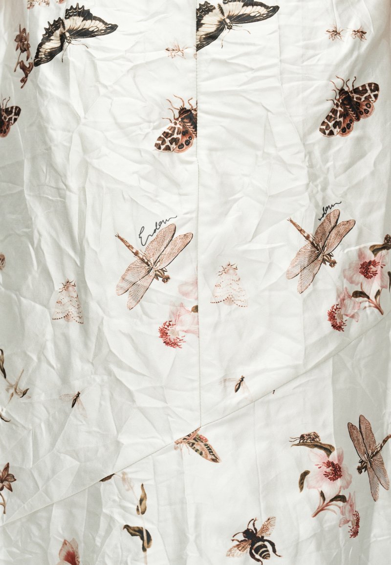 White fabric with a pattern of detailed brown and pink insects, including dragonflies, butterflies, bees, and small flowers, with visible wrinkles.