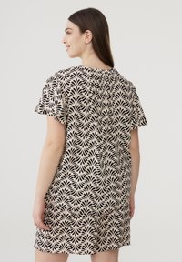 Abito a maniche corte in tessuto beige con un motivo botanico nero, caratterizzato da una vestibilità comoda e dettagli arricciati sul retro.
