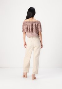 Olkapäälle laskeutuva dusty rose -värinen pitsipaita, kevyen paitapuseron päällä. Yhdistettynä vaaleisiin leveälahkeisiin housuihin ja beigeihin paksupohjaisiin korkokenkiin.