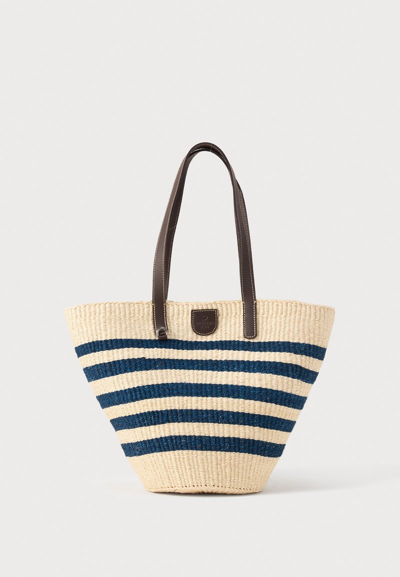 Sac cabas tissé avec des rayures horizontales bleu marine et beige et des doubles poignées en cuir marron foncé.