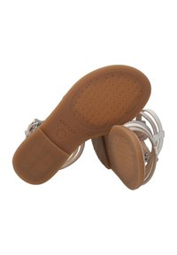 Sandalias Geox con una suela de goma marrón con un patrón texturizado, correas de color claro y un acento metálico en la hebilla.