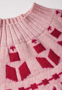 Rosa gestrickter Pullover mit einem gerippten Kragen. Der Körper zeigt ein geometrisches Muster in unterschiedlichen Rottönen, das Textur und visuelles Interesse schafft.