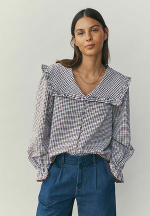 Bluza cu model cu guler mare cu volane, mâneci lungi și nasturi în față. Prezintă un design în carouri multicolor și manșete elastice la mâneci.