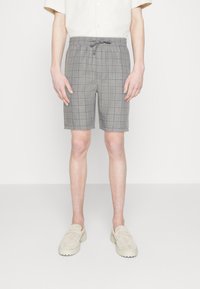 Pantalones cortos de cuadros grises con cintura elástica y cordón. Tienen una longitud ligeramente por encima de la rodilla y un corte relajado. Tejido texturizado.