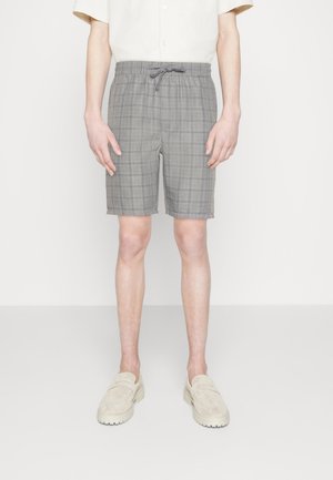 Pantalones cortos de cuadros grises con cintura elástica y cordón. Tienen una longitud ligeramente por encima de la rodilla y un corte relajado. Tejido texturizado.