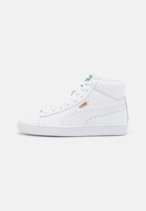 Weißer hoher Puma Basket Sneaker mit grünen Akzenten und goldenem Logo auf der Außenseite, seitlich vor einfarbigem Hintergrund.
