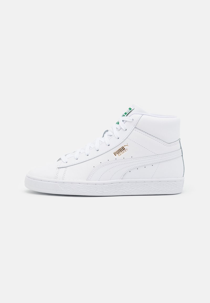 Baskets montantes blanches Puma Basket avec des accents verts et un logo doré sur le côté extérieur, vues de côté sur un fond uni.