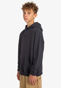 Sudadera gris oscuro de algodón, con bolsillo canguro, capucha con cordón y puños acanalados. Logo sutil en el pecho.