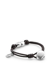 Pulsera de cuero negro con un charm de metal liso color plata grabado con "UNO de 50" y detalles metálicos para el cierre.