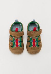 Braune Wildleder- und Mesh-Kinderschuhe mit verstellbarem Riemen, bunten Akzenten in Grün, Rot und Blau sowie einer strukturierten Sohle.