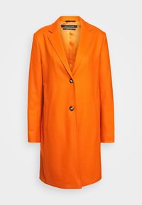 Orange uldfrakke med klassisk design, som har en revers med hak, enkelt knaplukning og to forlommer. Glat tekstur.