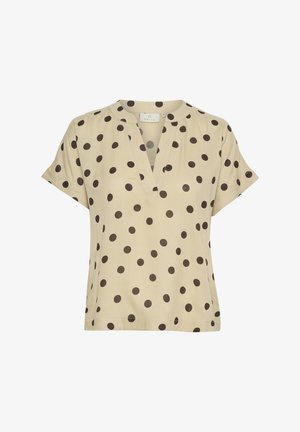 Beige kortärmad blus med V-halsringning, prydd med stora bruna prickar. Tillverkad av lätt tyg med en avslappnad passform.