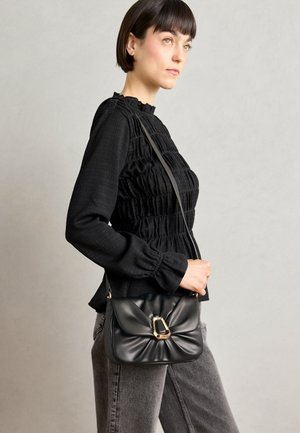 Zwarte leren schoudertas met een zachte, geplooide uitstraling, gouden hardware en een verstelbare schouderband. Ideale maat voor dagelijks gebruik.