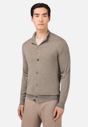 Hellgraue Strickjacke mit Kragen, die große braune Knöpfe und gerippte Manschetten an den Ärmeln sowie am Saum aufweist.